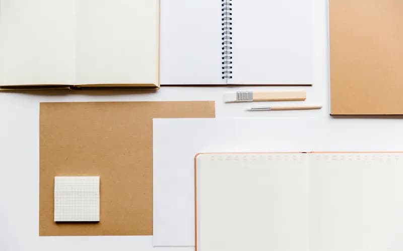 Cahiers ouverts, carnets à spirale et crayons